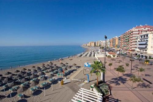 a beach with umbrellas and chairs and the ocean at Capitán - 2 habitaciones centro de Fuengirola in Fuengirola