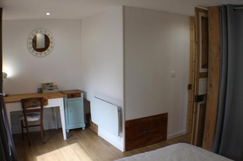 a bedroom with a desk and a bed and a desk and a chair at La maison verte in Arreau