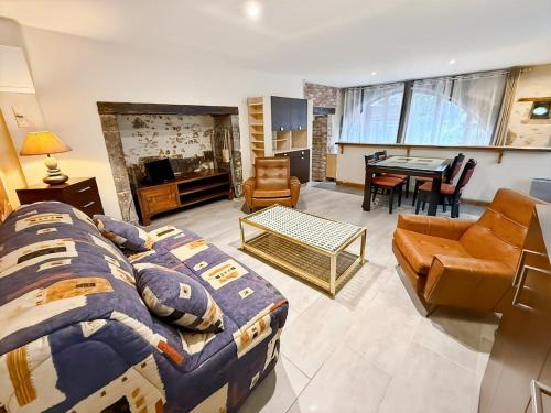 a living room with a bed and a dining room at Ancien moulin renove, terrasse au bord de l eau in Aurillac