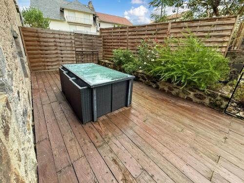 a television sitting on a deck in front of a fence at Ancien moulin renove, terrasse au bord de l eau in Aurillac