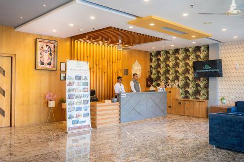 two men standing at a counter in a lobby at The Sky Imperial - Shahi Hotels & Resort in Nāthdwāra