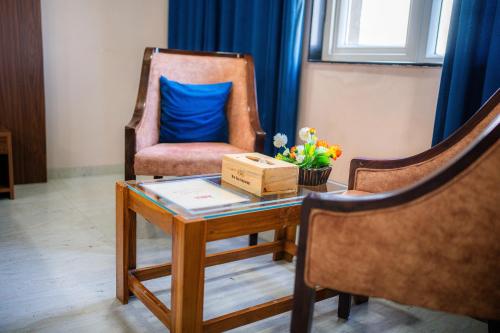 a room with a chair and a table with a blue pillow at The Sky Imperial - Shahi Hotels & Resort in Nāthdwāra