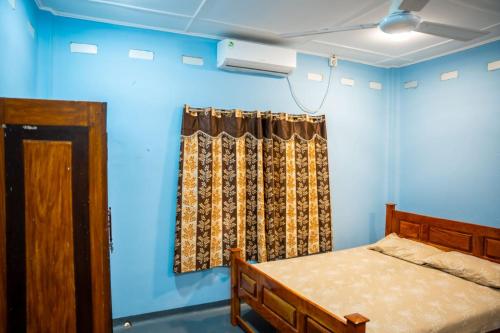 a bedroom with a bed and a window at Aananda Vasam in Jaffna
