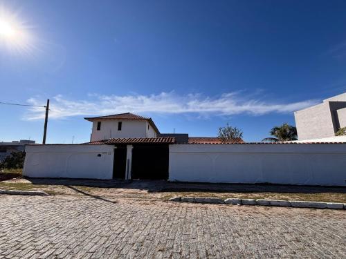 a white building with a fence and a brick road at Casa no Foguete com piscina in Škorak