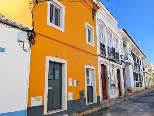 an orange building on a street in a city at Yellow House in Tavira