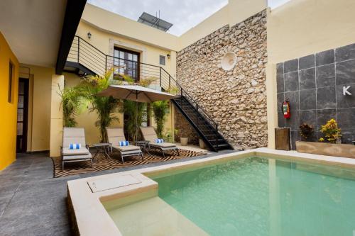 a house with a swimming pool and a patio at Kuxtal Hotel Boutique in Mérida