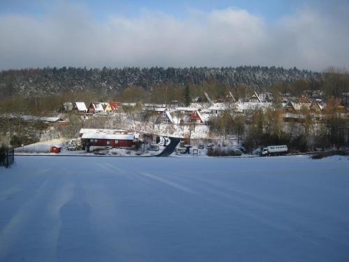 a large snow covered field next to a frozen lake at Holiday Home in Germany with Idyllic Nature in Berneburg