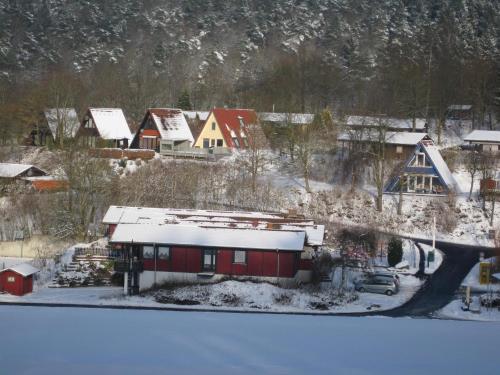 a snow covered village with a red building and houses at Holiday Home in Germany with Scenic Nature in Berneburg