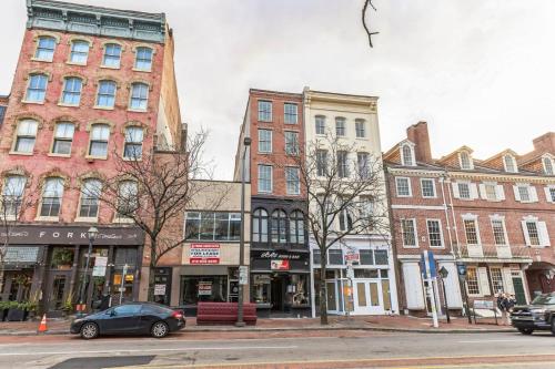 a city street with buildings and a car parked on the street at Large Bi-Level 2BR Loft in Old City that Sleeps 8 in Philadelphia