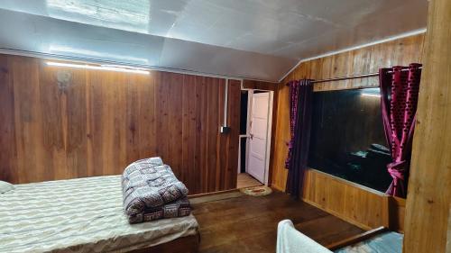a bedroom with a bed and a large aquarium at Forest Imax in Darjeeling