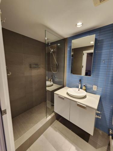 a bathroom with a shower and a sink and a mirror at Historic Downtown Escape in Vancouver
