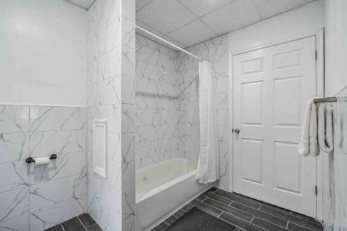 une salle de bain blanche avec une porte blanche et une baignoire dans l'établissement BRAND NEW Modern 2BR - Heart of Center City, à Philadelphie