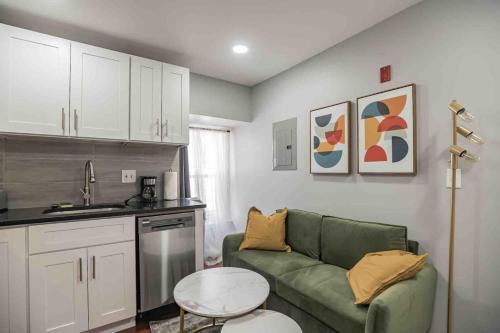 a living room with a green couch and a kitchen at Cozy 1BR - Center City - Sleeps 4 - 2 Beds in Philadelphia