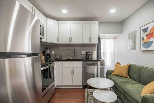 een keuken met witte kasten en een groene bank bij Cozy 1BR - Center City - Sleeps 4 - 2 Beds in Philadelphia