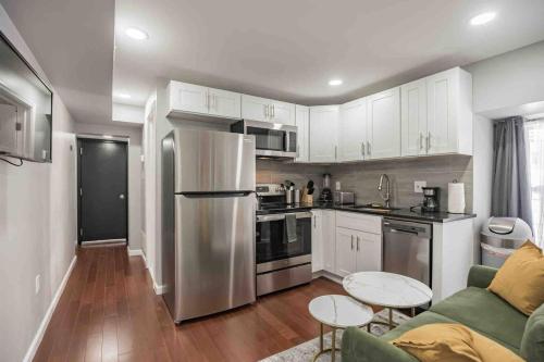 a kitchen with white cabinets and a stainless steel refrigerator at Cozy 1BR - Center City - Sleeps 4 - 2 Beds in Philadelphia
