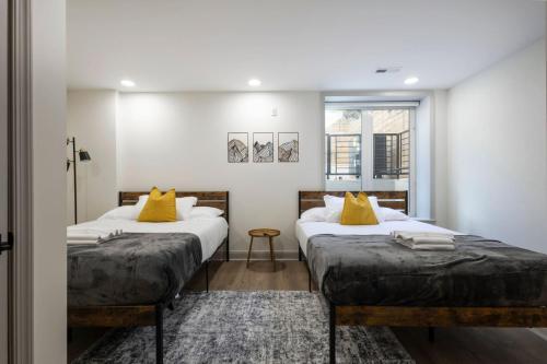 - 2 lits avec des oreillers jaunes dans une chambre dans l'établissement 2BR - Fairmount Park -10 mins to DT - Sleeps 10, à Philadelphie