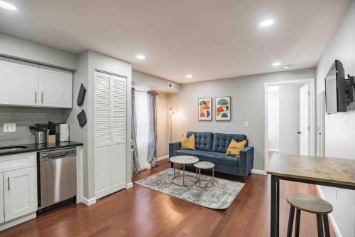 a living room with a blue couch and a kitchen at Modern and Stylish Center City 1BR - Perfect Location in Philadelphia