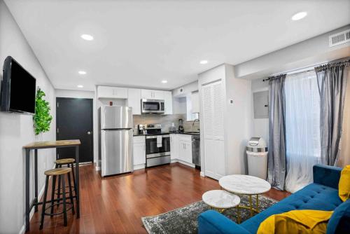 a living room with a blue couch and a kitchen at Modern and Stylish Center City 1BR - Perfect Location in Philadelphia