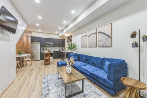 a living room with a blue couch and a kitchen at New 2BR Across from Fairmount Park - 10 Mins to DT in Philadelphia