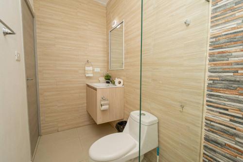 a bathroom with a toilet and a glass shower at Modern 2BR Condo with Pool in Bayahibe