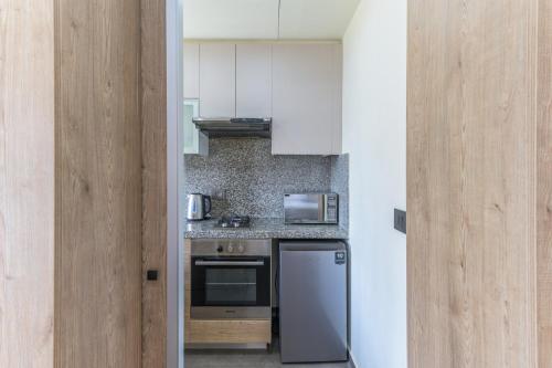 a kitchen with a stove and a refrigerator at Apex Studio & Balcony in Jounieh in Al Bāţiyah