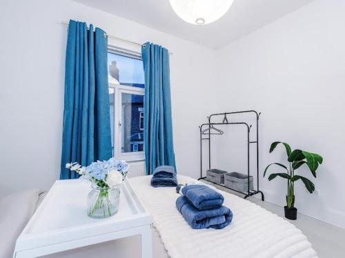een kamer met een bed met blauwe kussens en een raam bij Sleep7, Pool Table, TTennis, Free Parking, 3BR in Manchester