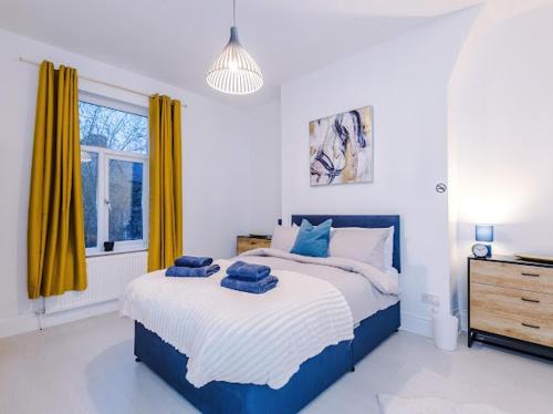 een slaapkamer met een blauw en wit bed en een raam bij Sleep7, Pool Table, TTennis, Free Parking, 3BR in Manchester