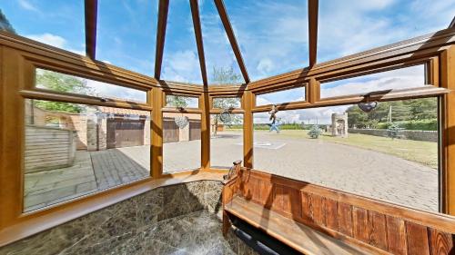 a view from the inside of a building with large windows at The Barn & The Log Cabin, Sleeps 12, 2 Hot Tubs, Near Durham & Bishop Auckland in Durham