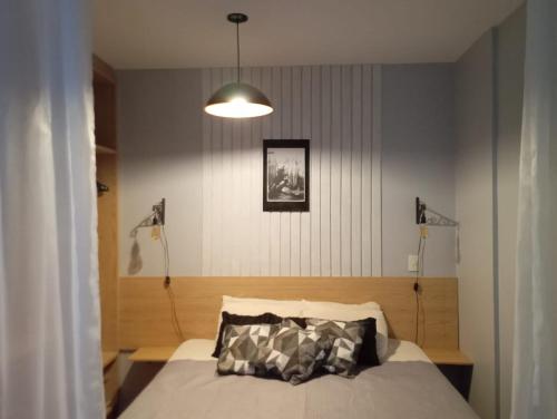 1 dormitorio con 1 cama y luz colgante en Golden Dolphin Express 403, en Caldas Novas
