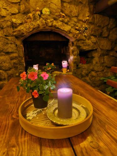 a candle and flowers on a table with a fireplace at Soba Erika in Fužine