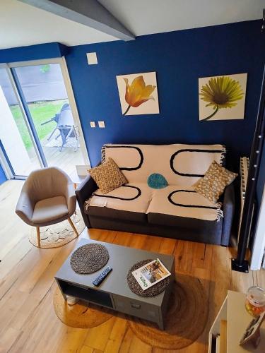 a living room with a couch and a table at La maisonnette de Joséphine in Saint-Jean-des-Mauvrets