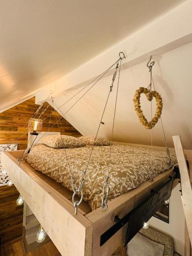 a bed swing with a heart hanging on the wall at Le Perchoir " Une nuit suspendu dans le temps" in Chessy
