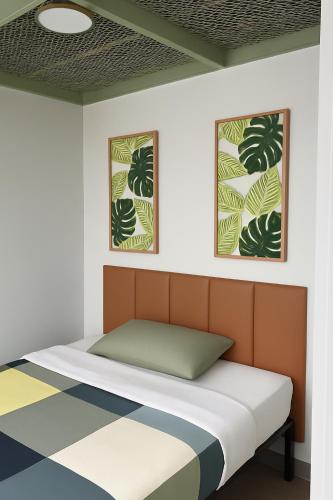 a bed in a room with two pictures on the wall at CityNest Hotel in New York