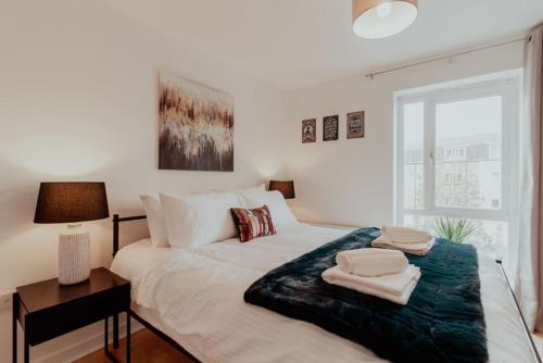 a bedroom with a bed with towels on it at The Diickens Den - Stylish Rochester 1BR Flat - Sleeps 4 - Walk to High St, Castle & Station with Secured Parking - Contractor - Friendly and Ideal for Long Stays in Rochester