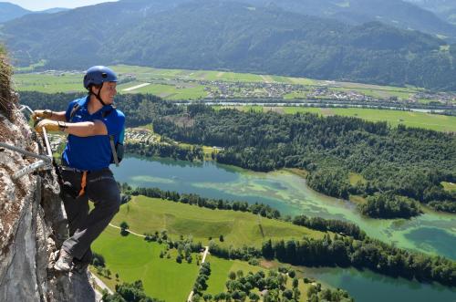 a man standing on the edge of a mountain overlooking a river at Landhaus Alpbach in Alpbach