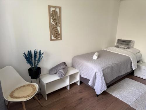 a small bedroom with a bed and a chair at Juicy Private Apartments with Jacuzzi in Szentendre