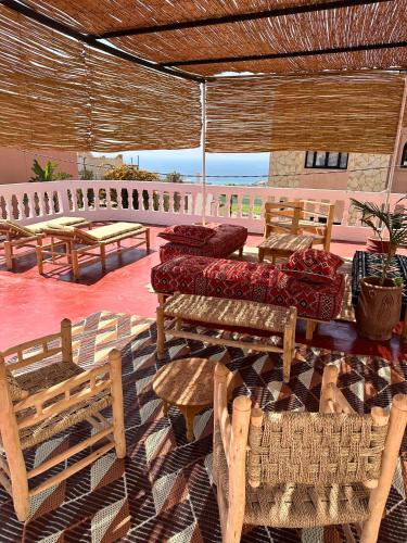 a patio with couches and chairs and a table at Dar Al-Andalus in Tamraght Ouzdar