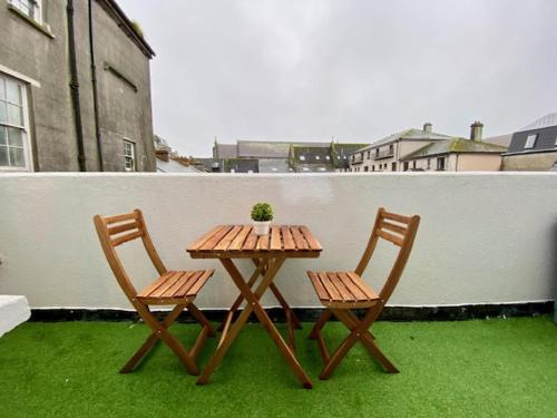 a wooden table and two chairs on a balcony at Location! Location! City Centre Townhouse Sleeps 6 in Galway
