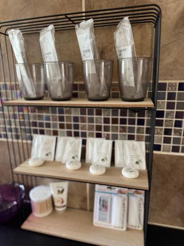 a shelf with four plastic bowls and towels at Juicy Private Apartments with Jacuzzi in Szentendre