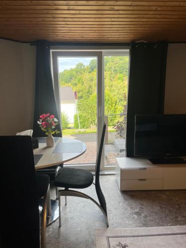 a living room with a table and a large window at Gemütliches Feriendomizil*Eifel* in Bad Münstereifel