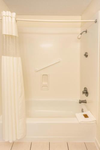 a bathroom with a tub and a shower curtain at Players Club Resort in Hilton Head Island