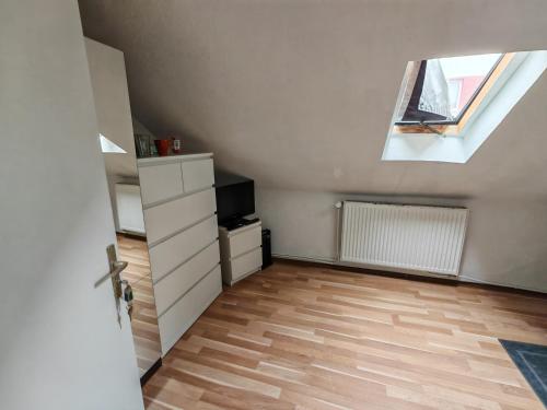 Una habitación abuhardillada con tragaluz y televisión. en Privat Zimmer in Zwei-Zimmer-Wohnung als 2er WG, en Colonia