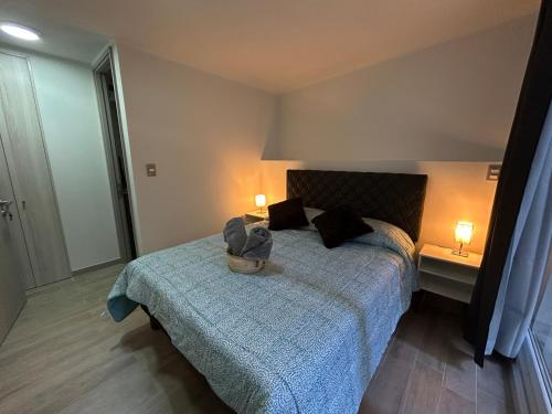 1 dormitorio con 1 cama con manta azul y 2 lámparas en 1H1B I Movistar Arena I Con Estacionamiento, en Santiago