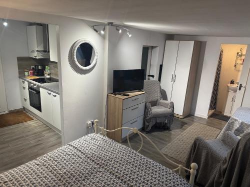 a bedroom with a bed and a tv and a kitchen at Garden lodge in Broadwater