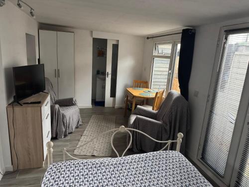 a living room with a bed and a television at Garden lodge in Broadwater
