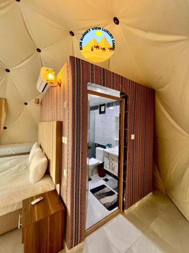 a room with a tent with a bed and a mirror at RUM SUN SET VIEW BUBBLE lUXURY CAMP in Wadi Rum