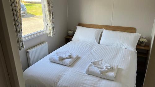a bedroom with a bed with towels on it at Newquay Bay Resort 181 in Newquay Bay Resort