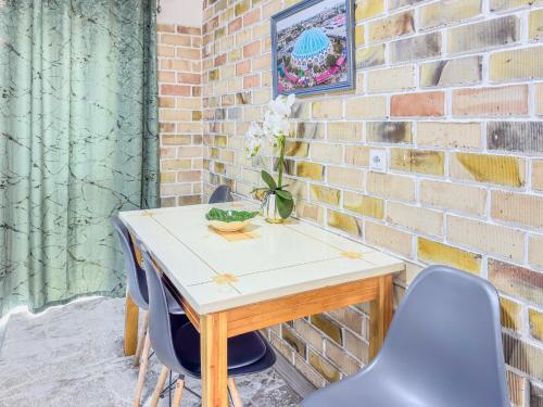 a table with two blue chairs and a brick wall at Komolon in Tashkent