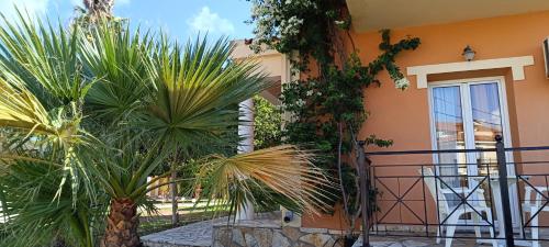 a house with palm trees in front of it at Elanthi Village Apartments in Kalamaki