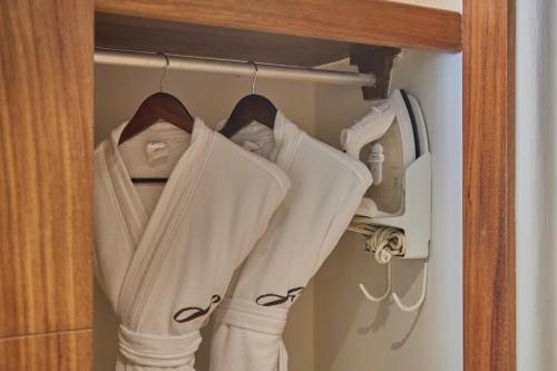 a closet with white clothes hanging on a door at Fiesta Americana Condesa Cancun - All Inclusive in Cancún